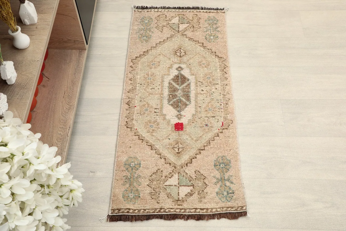 Overhead view of the tan vintage doormat, showcasing its central geometric medallion and tribal motifs.