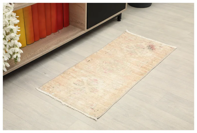 Full top view of the 1x3 beige vintage Anatolian rug on a light floor, angled from above