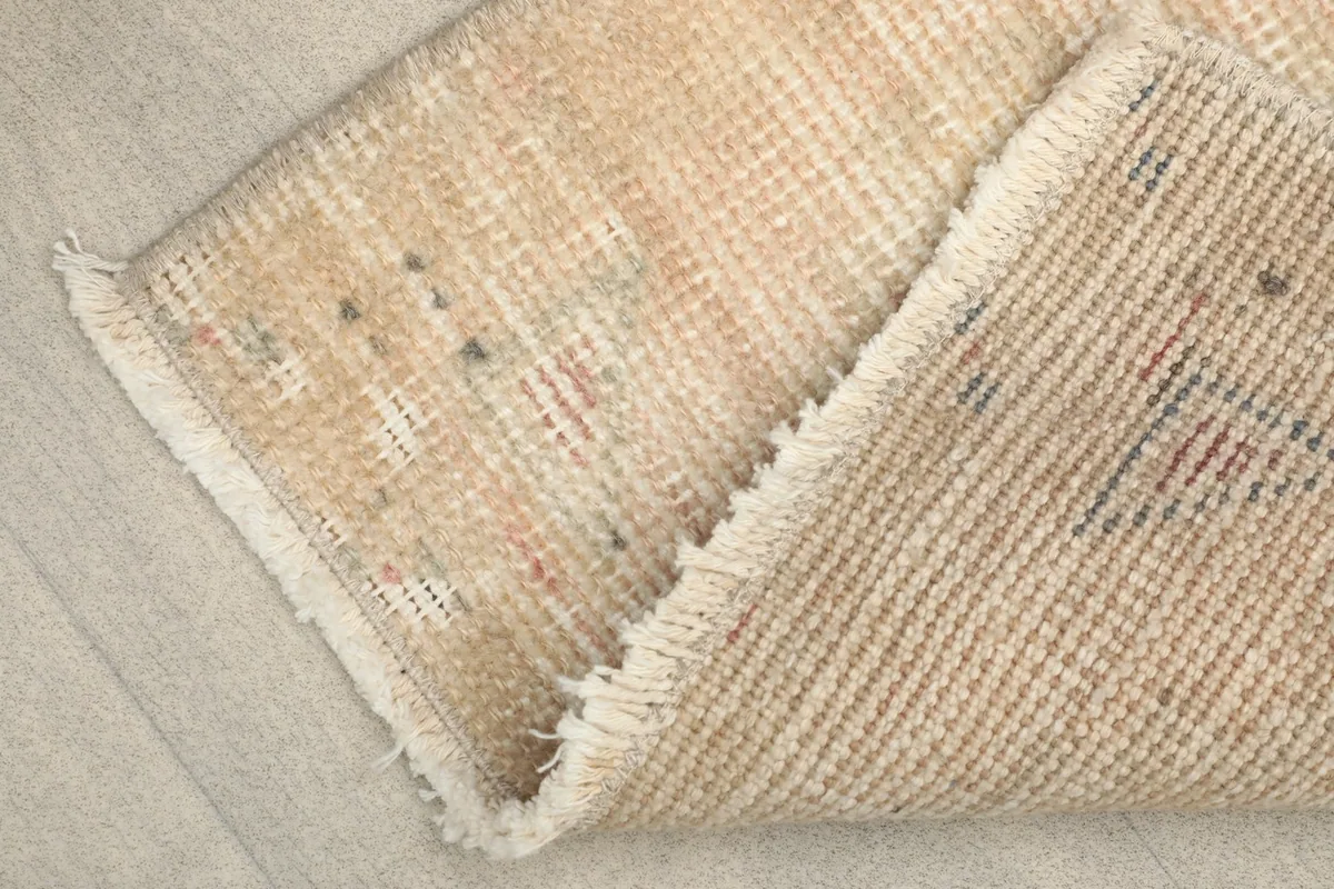View of the back of the hand-knotted rug, revealing the cotton foundation and tight weave