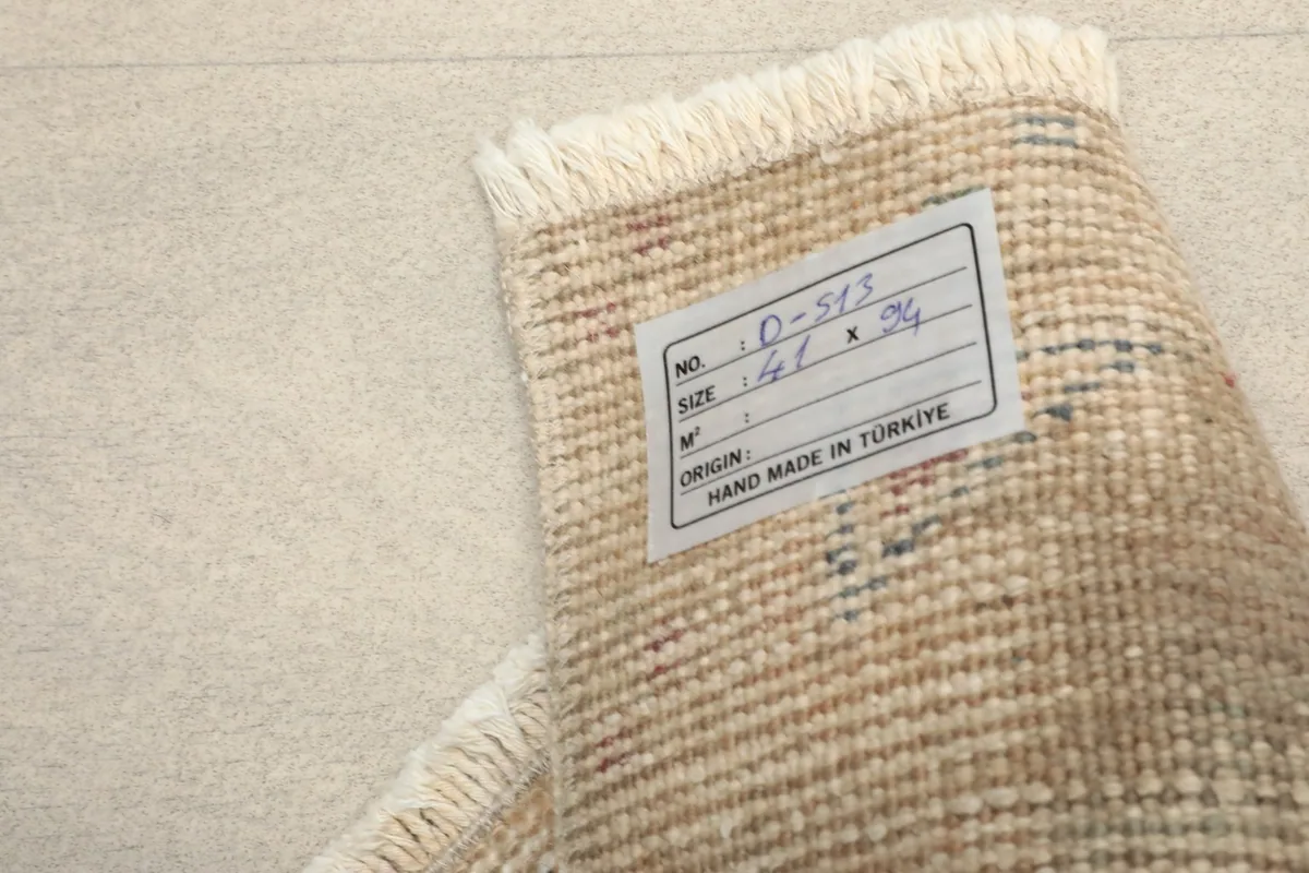 Close-up of the label on the back of the rug, indicating its size, origin, and hand-knotted quality