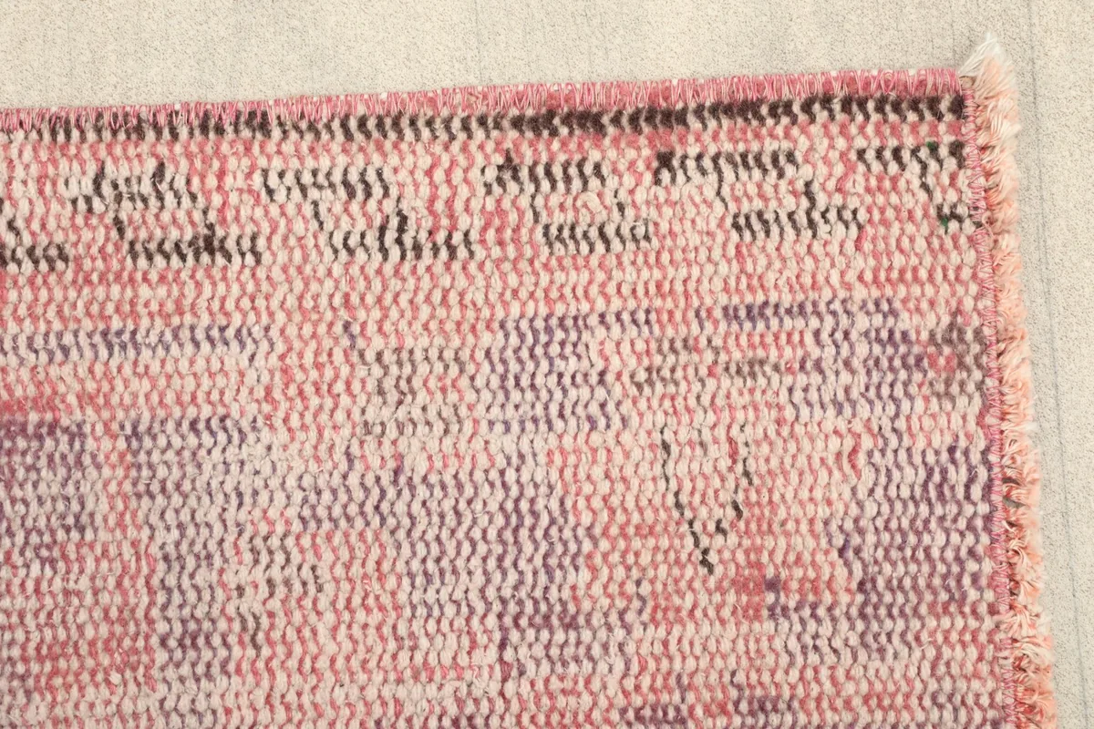 Close-up of the rug's edge, revealing the texture and subtle color variations.