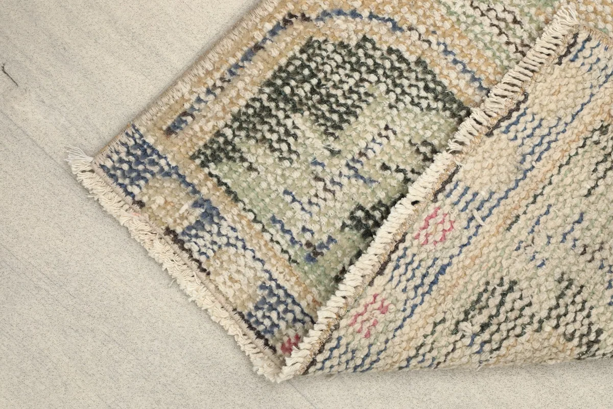 Rug folded to show the back and front texture, emphasizing the hand-knotted construction.