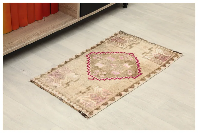 Full top view of the 1'4" x 2'4" vintage Anatolian rug with beige, pink, and brown colors on a white background.