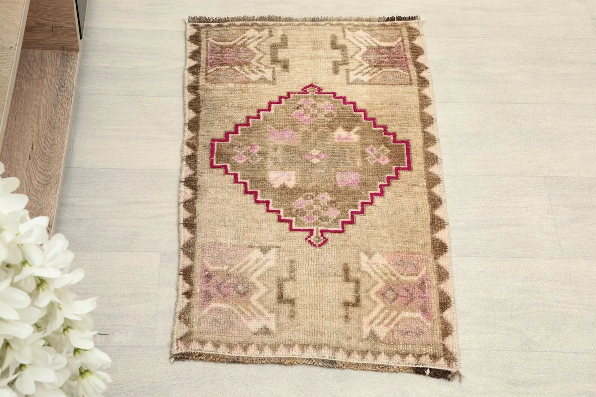 Overhead view of the small hand-knotted wool rug, showing its central medallion and tribal patterns.