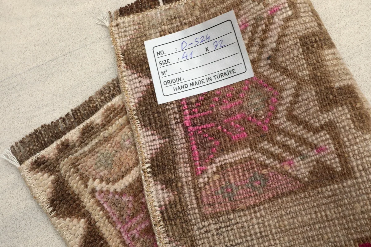 Close-up of the rug's back with a label indicating its origin as hand-made in Turkey.