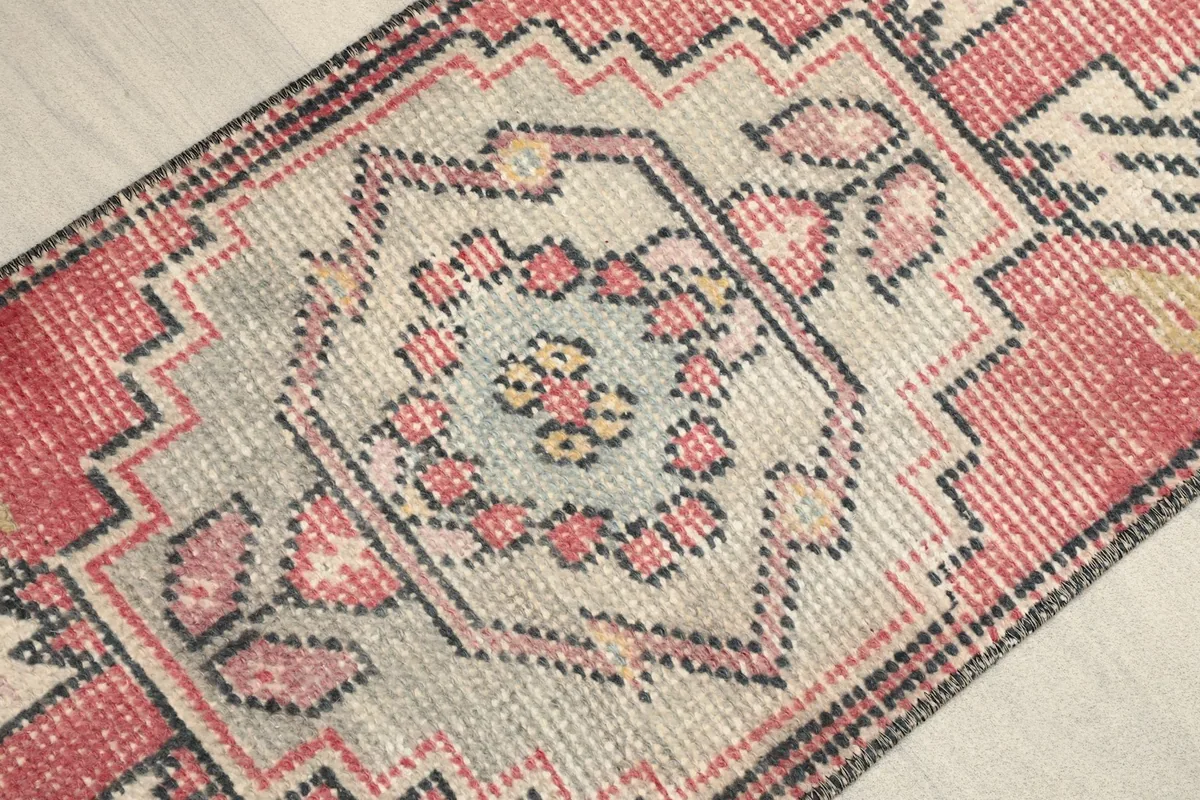 Close-up of the rug's central gray medallion with rose and yellow accents