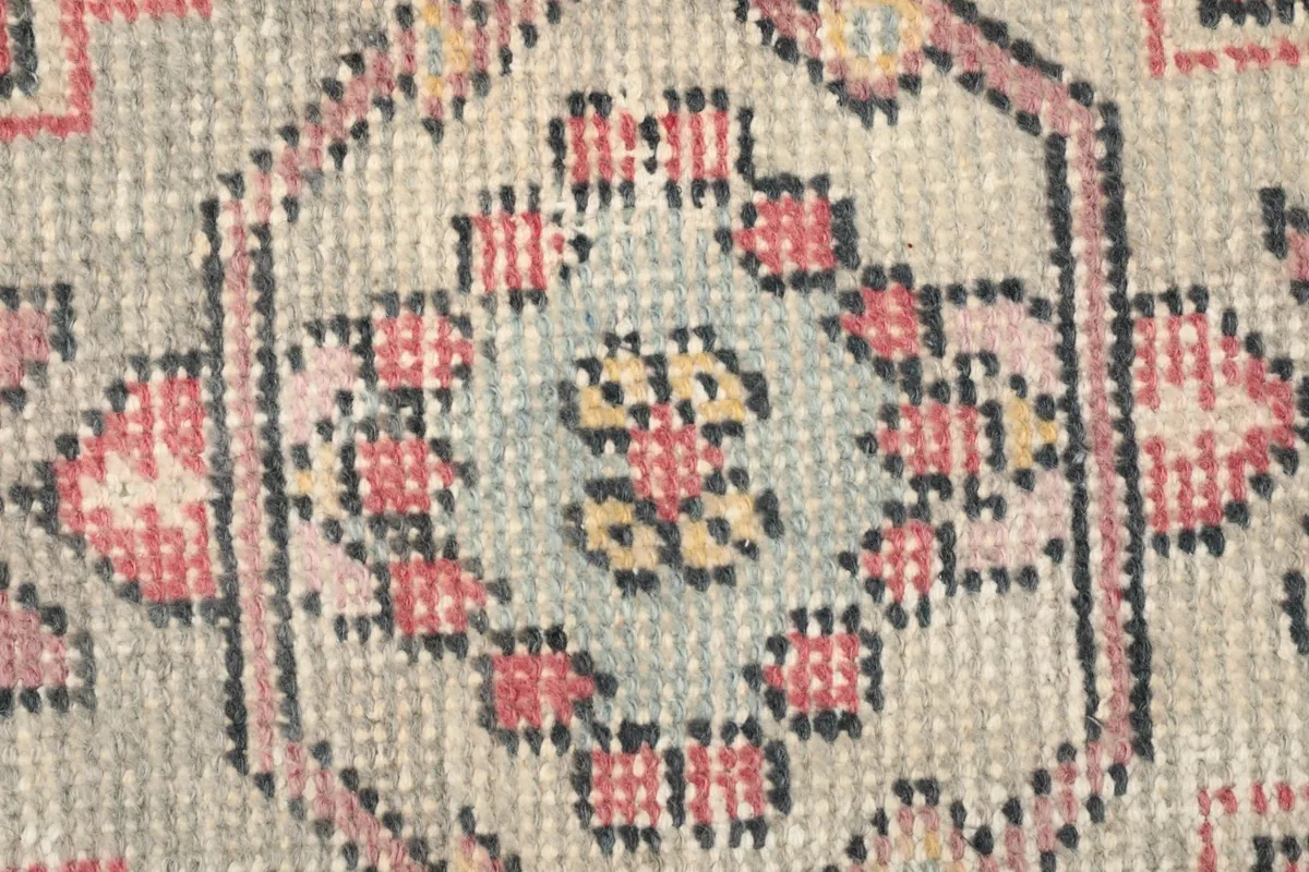 Detailed view of the intricate knotting and color variations within the medallion