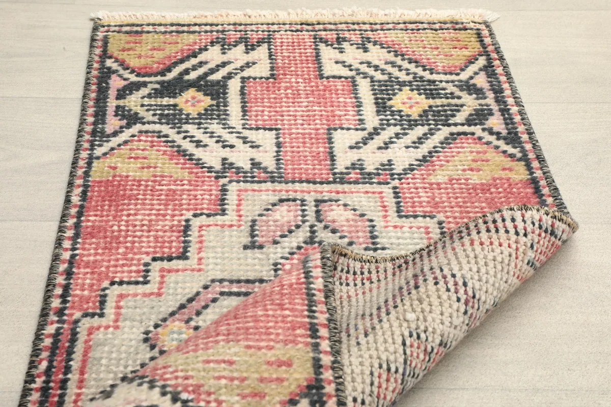 Partial view of the rug with one end folded, revealing the reverse side