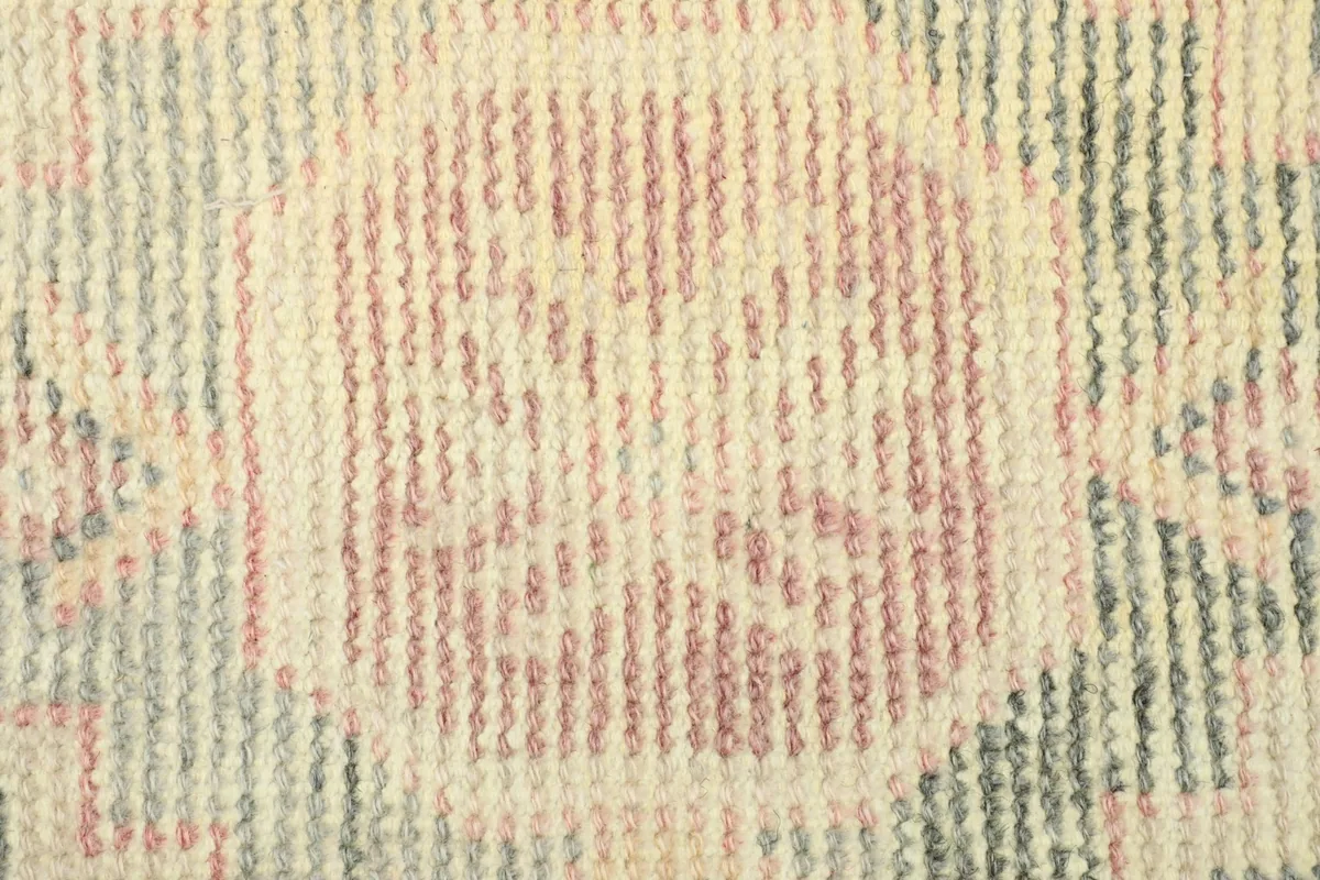 Close-up detail of the central pink geometric medallion on the vintage rug