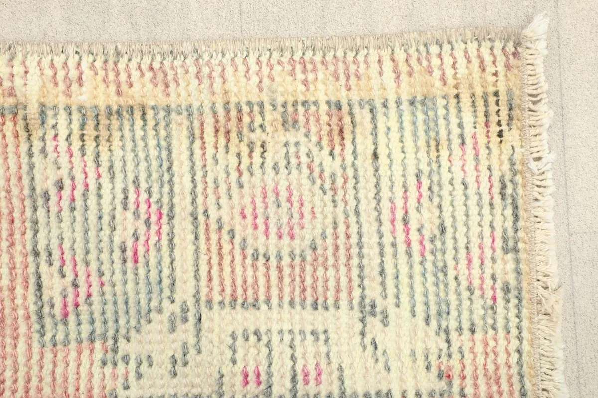 Close-up of the rug's edge, revealing the hand-knotted texture and color blend
