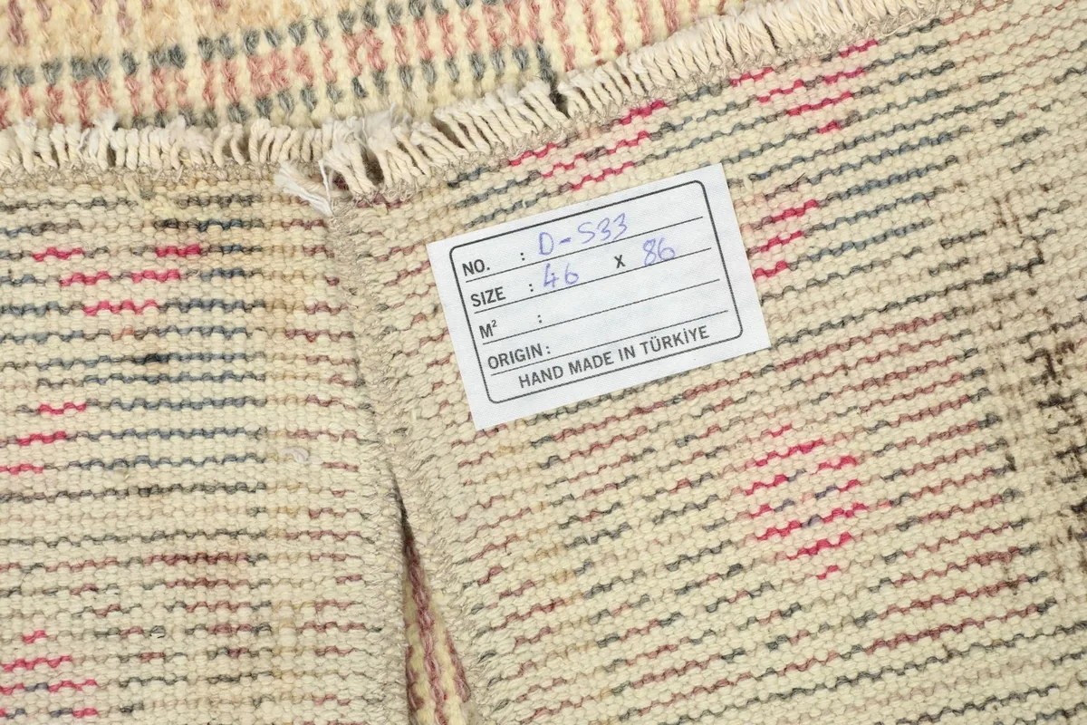 Back of the rug showing the hand-knotted cotton foundation and product label