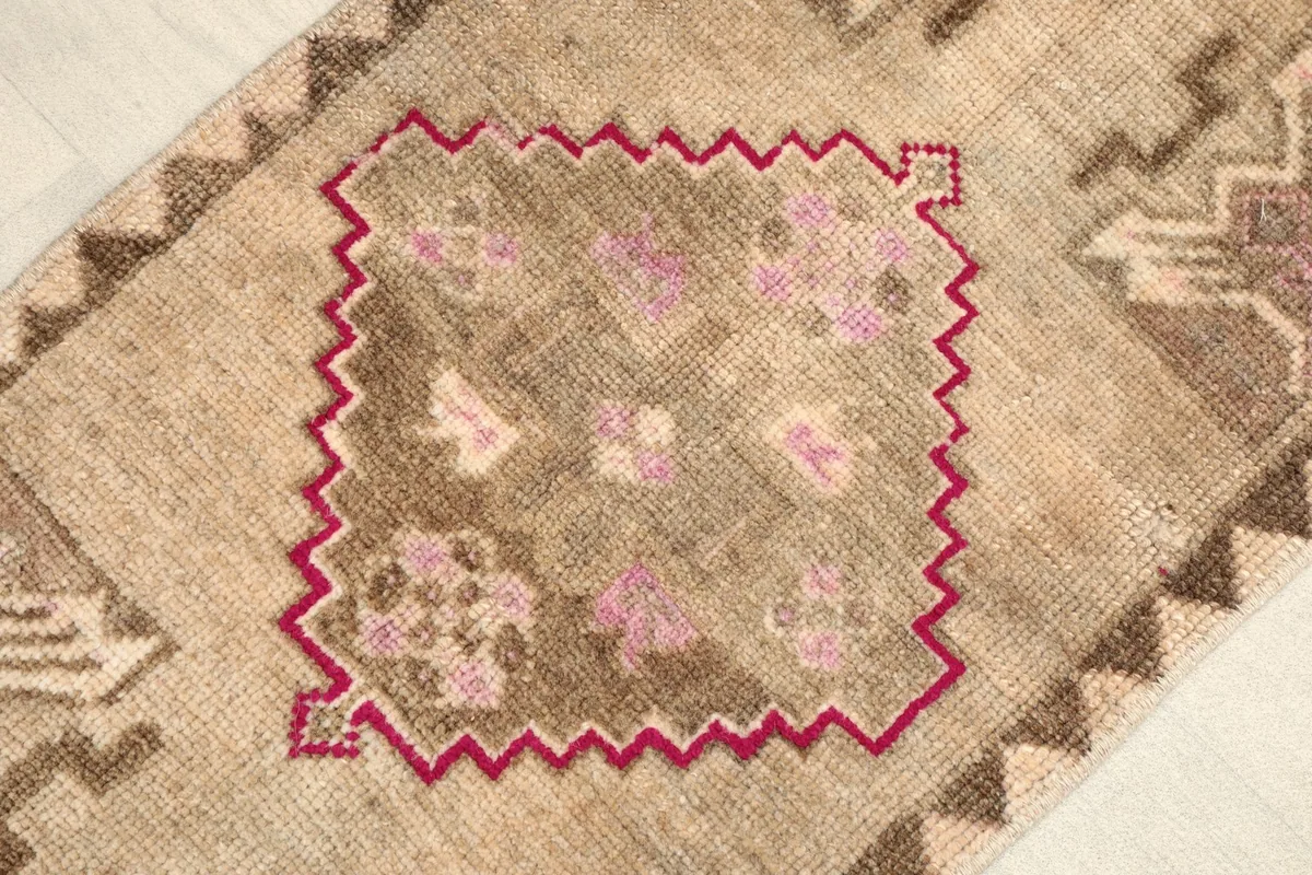 Close-up view of the central rose geometric motif and surrounding beige field.