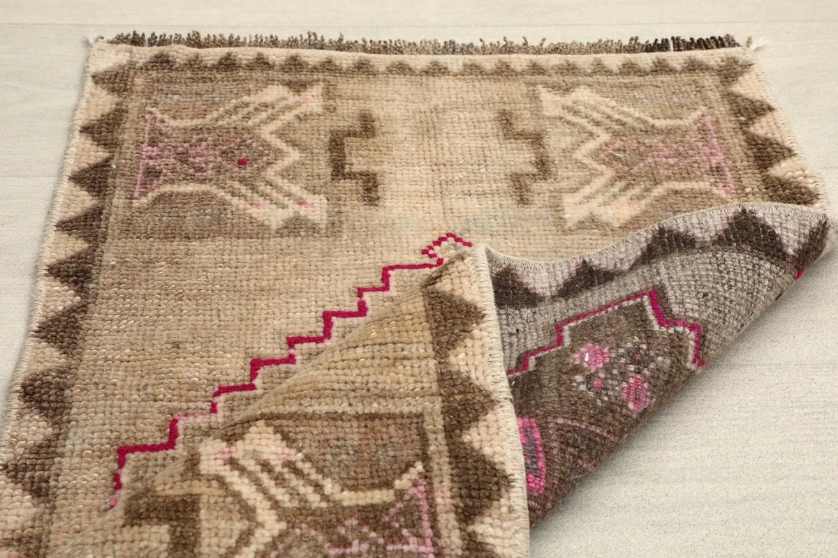 Rug folded to show the back and construction, with the central motif visible.