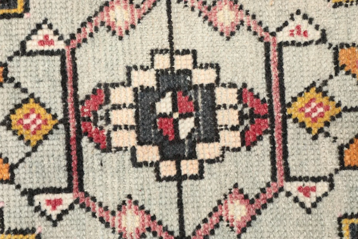 Detailed view of the intricate knotting and colors within the gray central medallion.