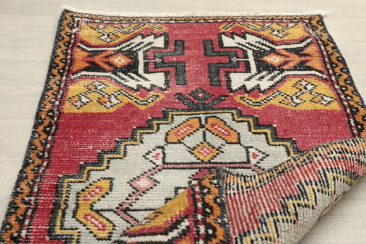 Rug partially folded, revealing the reverse side and the hand-knotted construction.