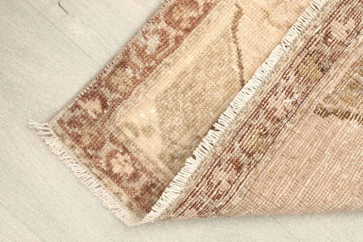View of the underside of the rug, showing the hand-knotted cotton foundation