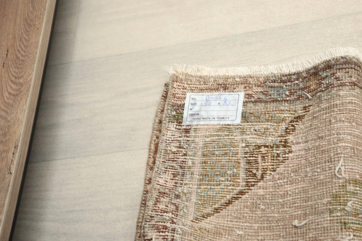 View of the rug's label on the back, showing its origin and material details