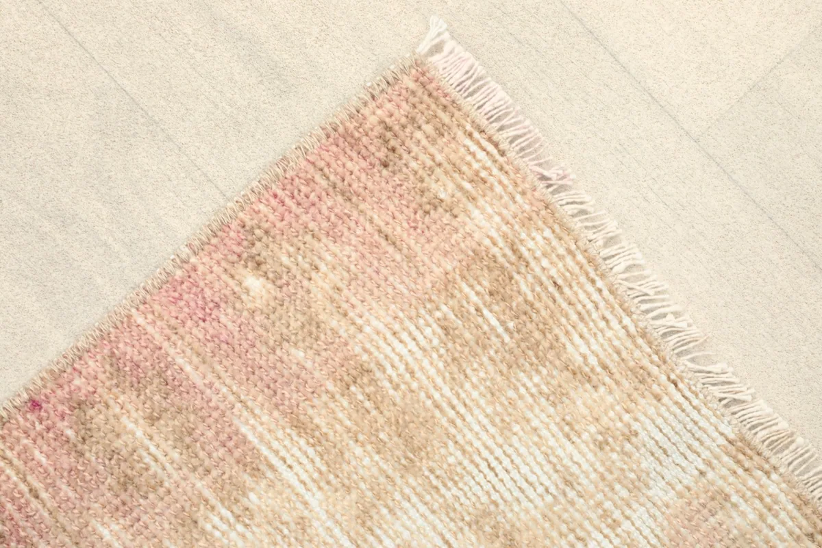 Angled view of one corner of the rug, showing the short fringe and the soft color transitions.