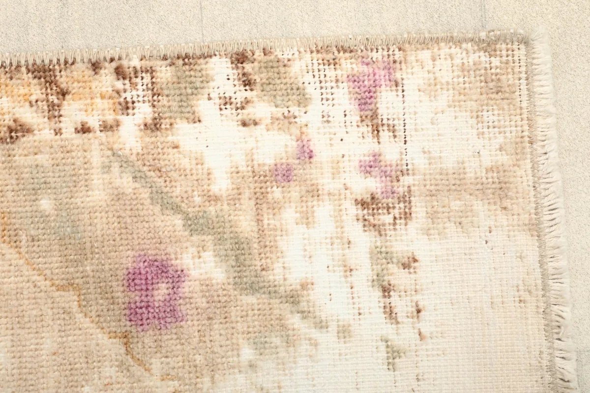 Detail of the rug's edge, showing the subtle brown border and the short fringe.