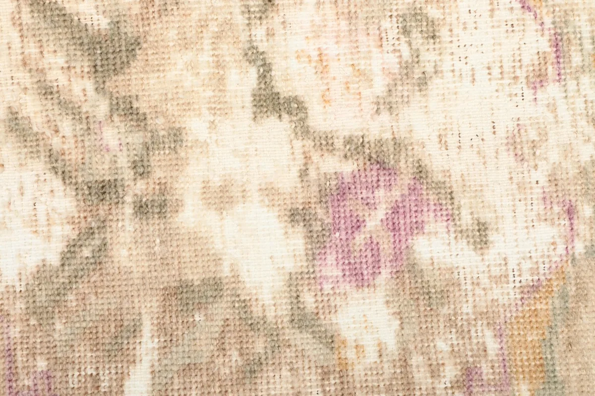 Extreme close-up view of the low wool pile and the hand-knotted texture of the rug.