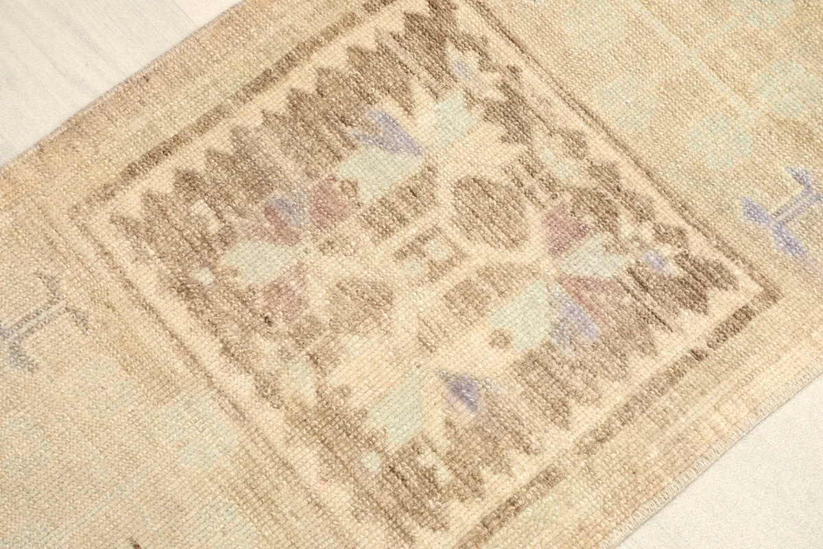 Close-up view of the central brown and purple tribal medallion and surrounding beige field.