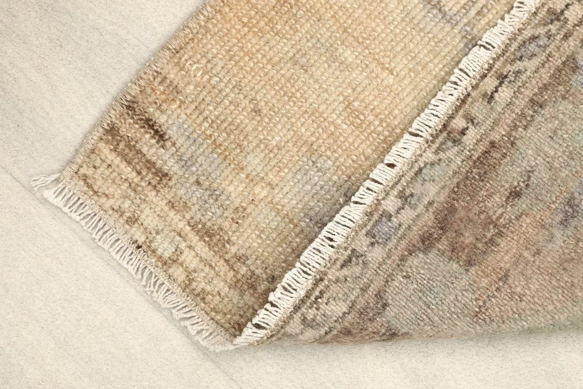 View of the rug folded, showing the thickness of the hand-knotted wool pile and cotton foundation.
