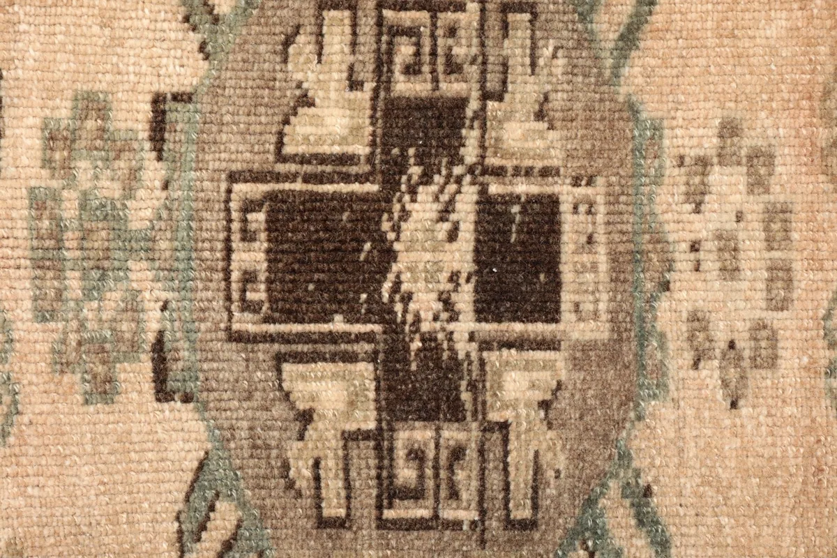 Close-up detail of the central geometric medallion with brown, gray, and green tones.