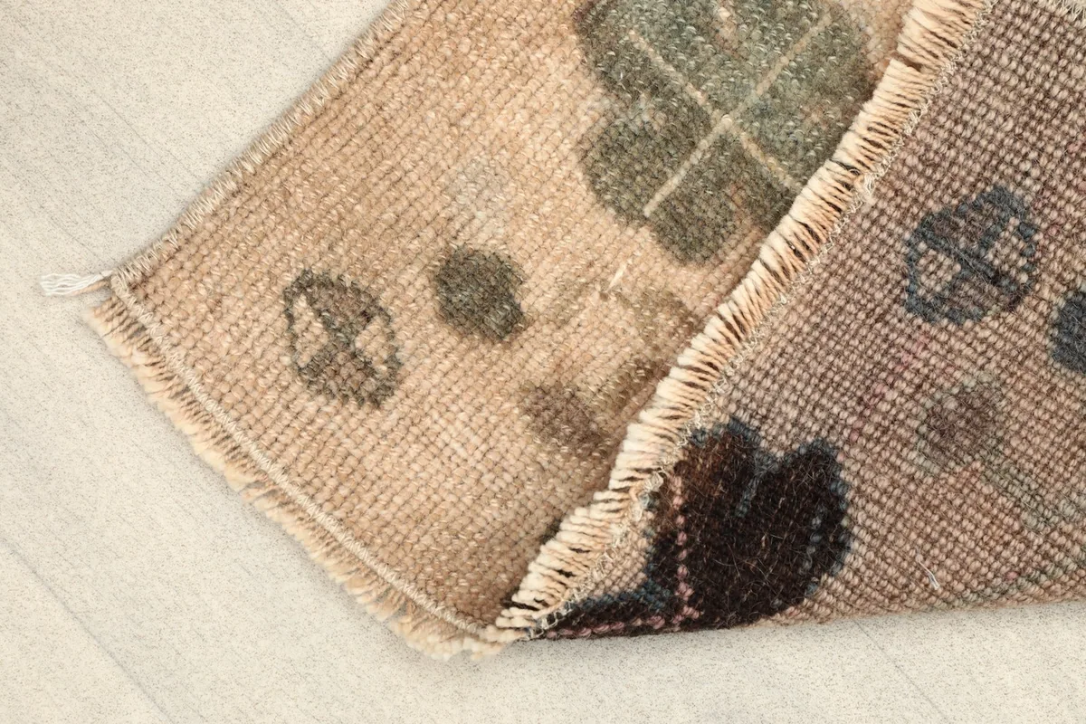 Folded corner of the rug, revealing the thickness of the wool pile and cotton foundation.