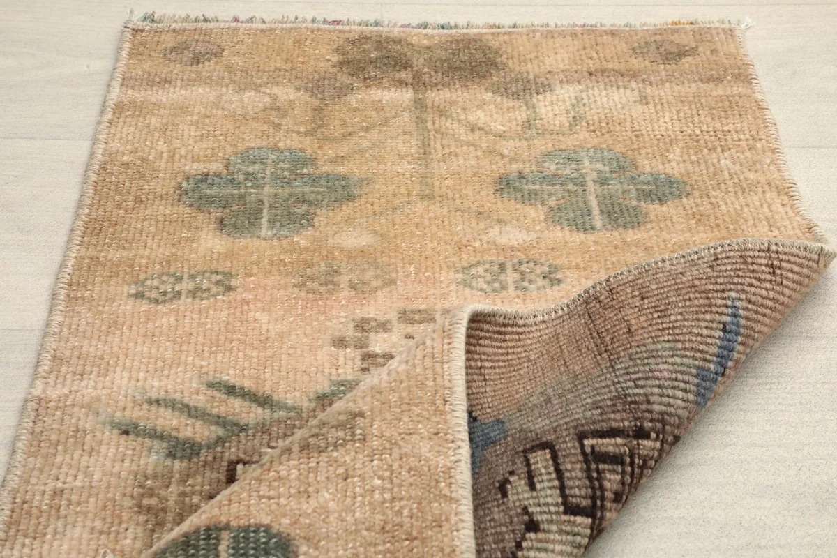 Rug partially folded, showing the overall pattern and the back of the hand-knotted construction.