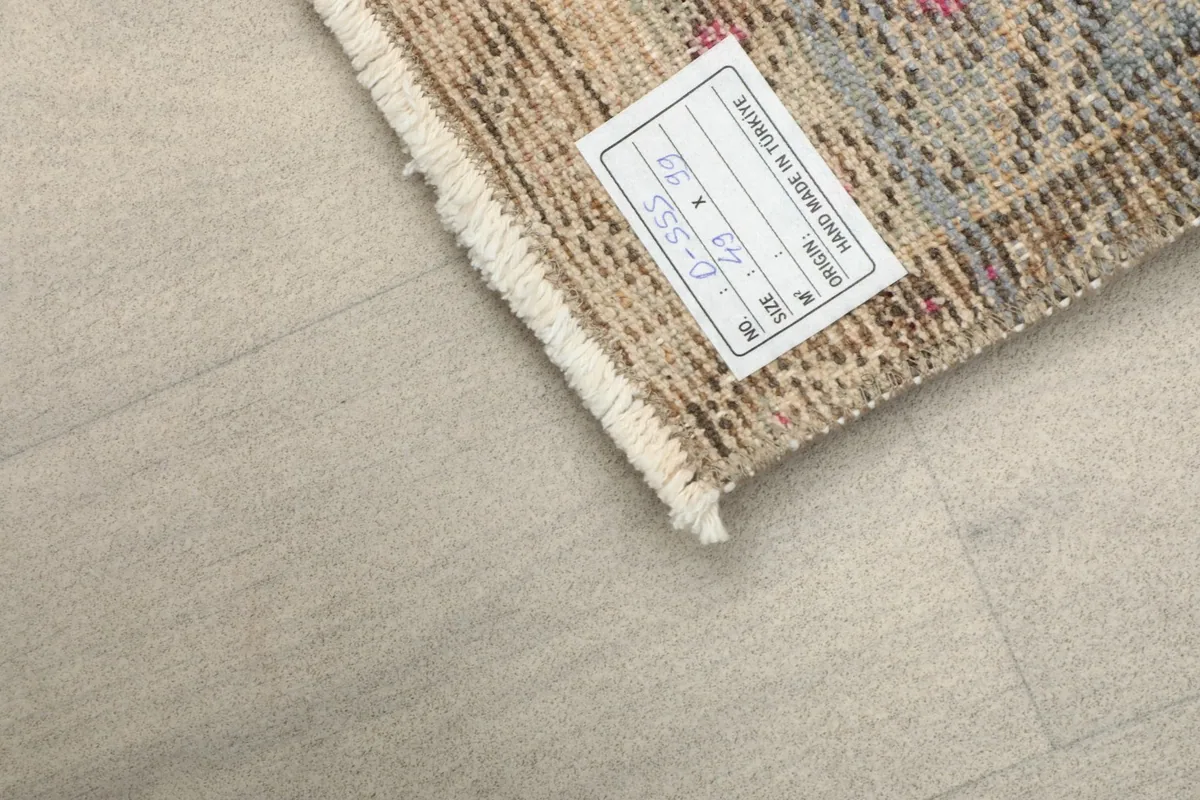 Back of the rug showing the hand-knotted cotton foundation and the product label.