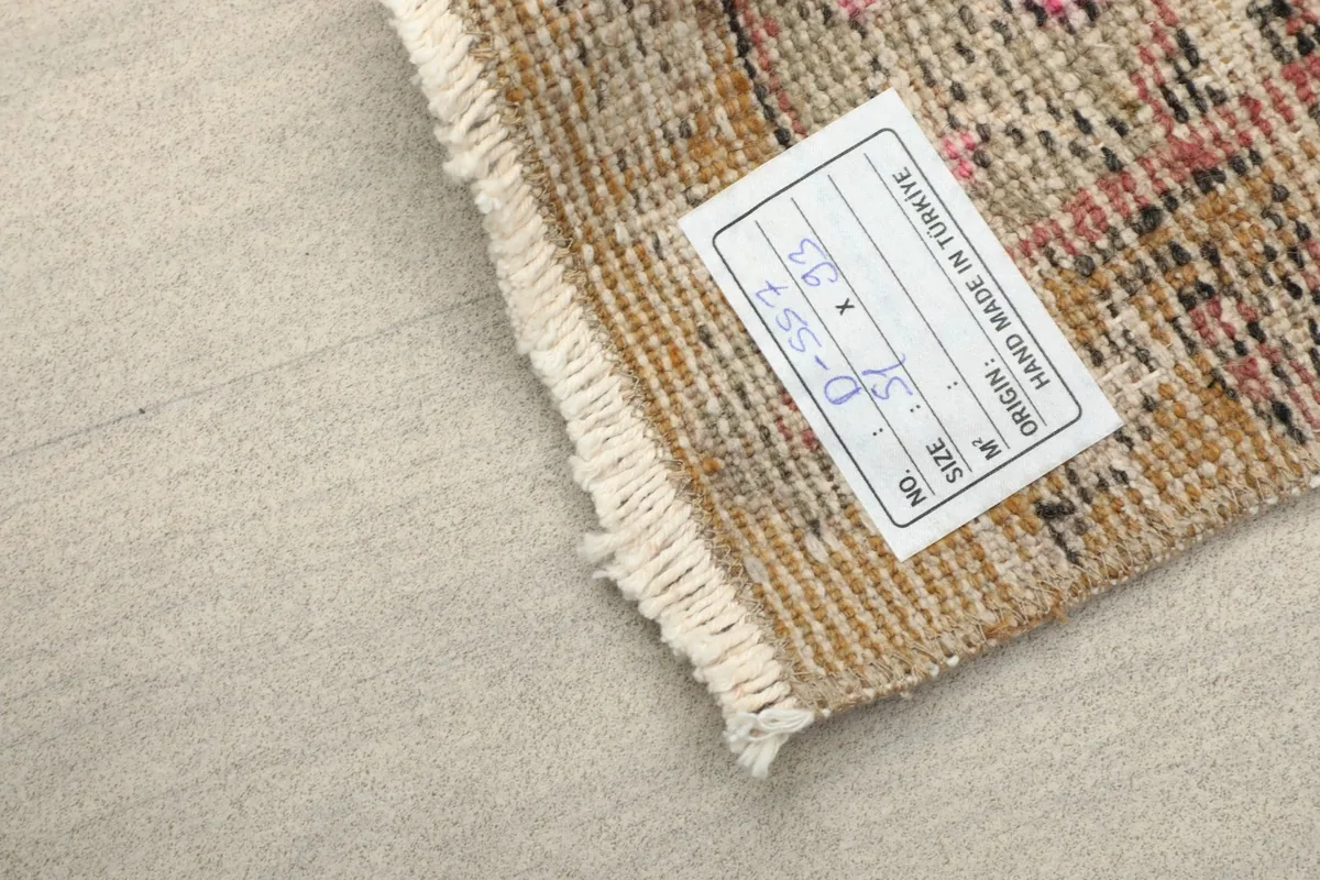 Back of the rug showing the hand-knotted weave, cotton foundation, and a product label.
