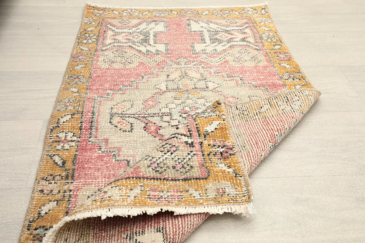Rug partially folded, displaying the full design and the flexible nature of the hand-knotted material.