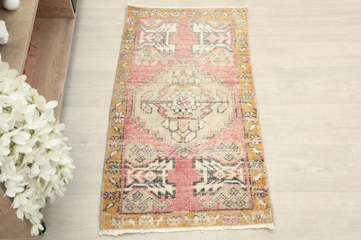 Overhead view of the rug, showcasing its rose field, gold border, and geometric tribal patterns.