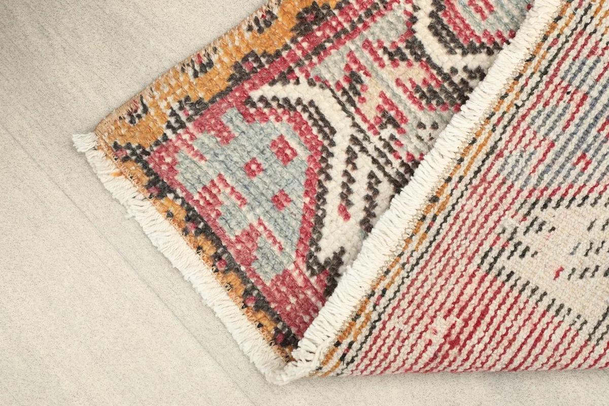 View of the rug folded to show the thickness of the wool pile and the construction.