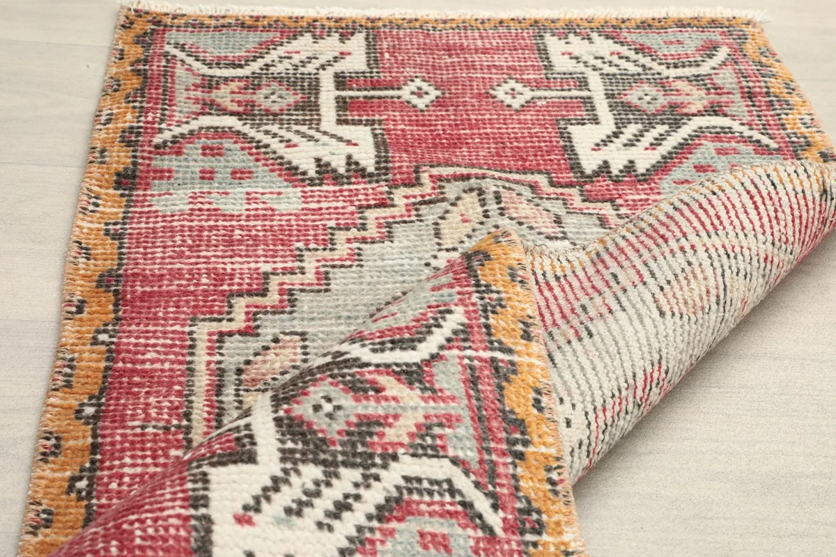 The rug partially folded, revealing the reverse side and the visible texture of the hand-knotted foundation.