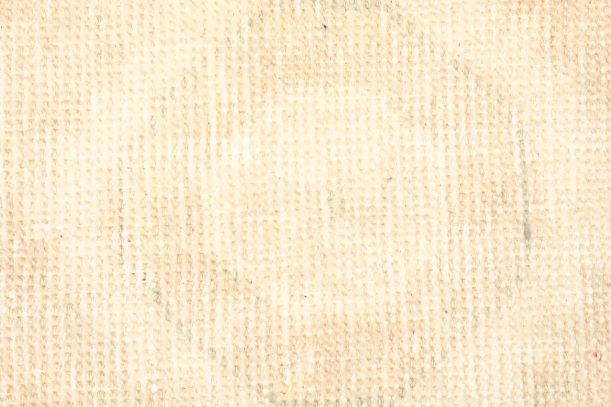 Close-up detail of the hand-knotted wool pile and the faded geometric design