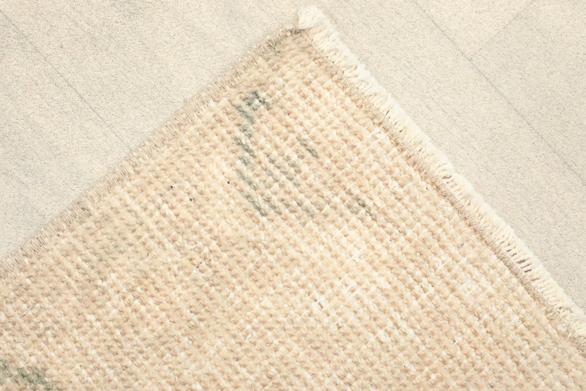 Corner view of the rug's back, revealing the cotton foundation and tight hand-knotting