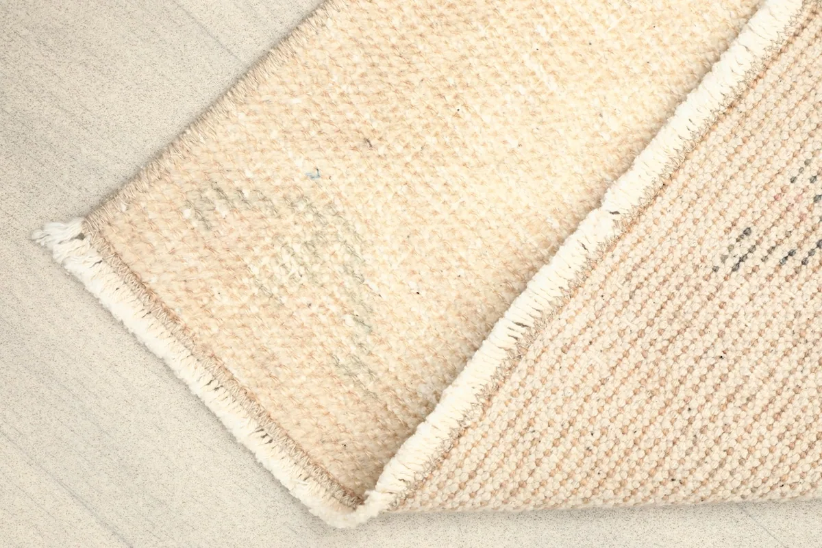 Rug folded to display both the front pile and the sturdy cotton foundation on the back