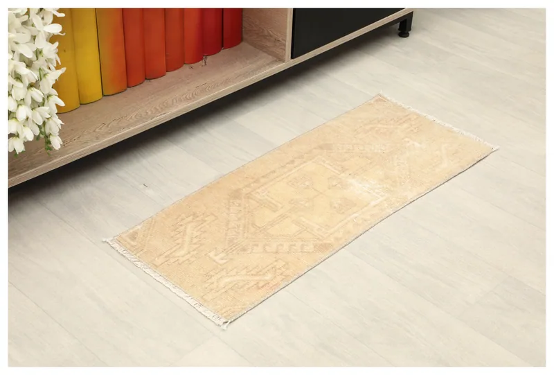 Full top view of the beige tribal vintage Anatolian doormat on a white background.