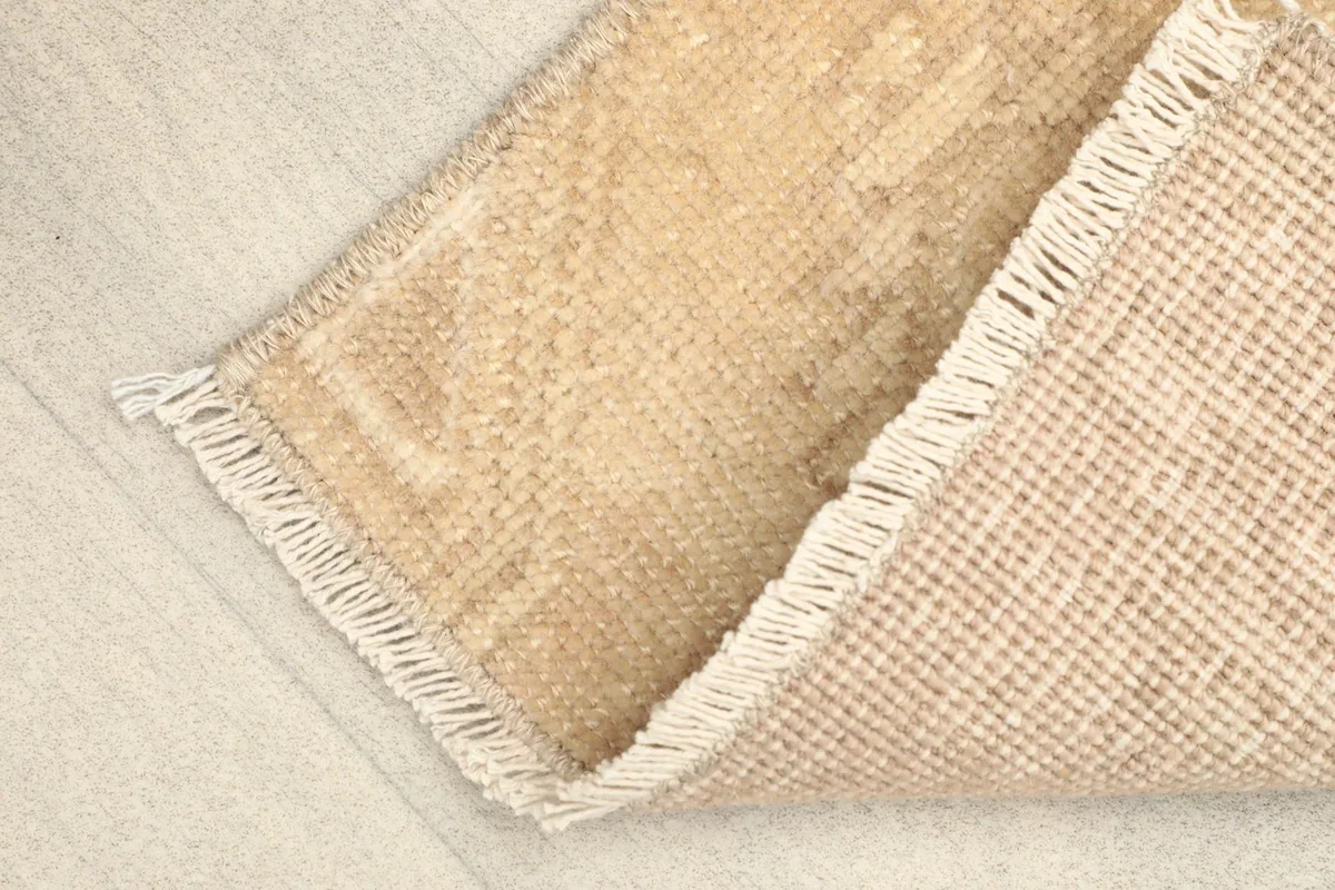 View of the back of the rug, showing the cotton foundation and hand-knotted construction.