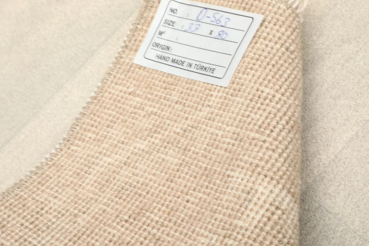 Label on the back of the rug indicating its origin, size, and hand-made quality.