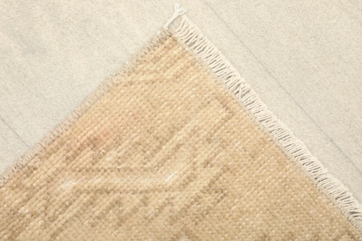 Corner view displaying the short, natural fringe and the tight weave of the rug's edge.