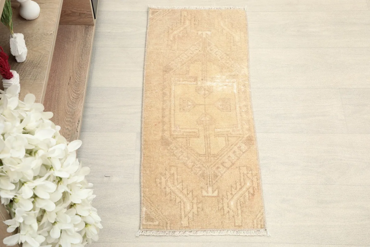 Overhead view of the hand-knotted beige doormat, showcasing its full design and subtle color variations.