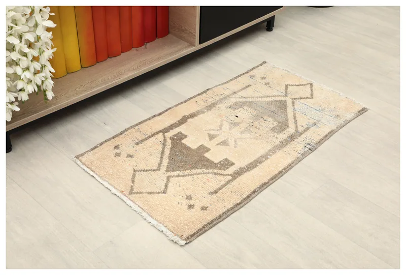 Full top view of the cream and brown vintage Anatolian doormat on a light floor.