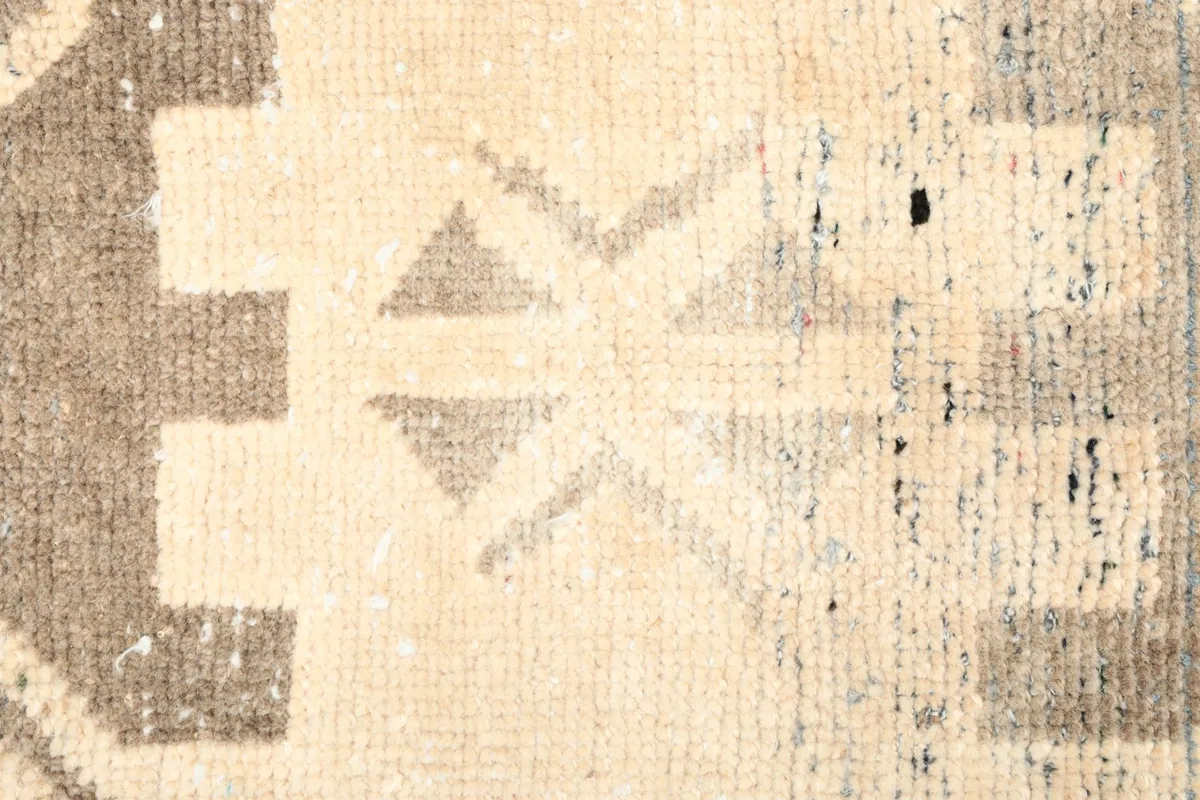 Close-up of the central geometric motif and the distressed areas of the rug.