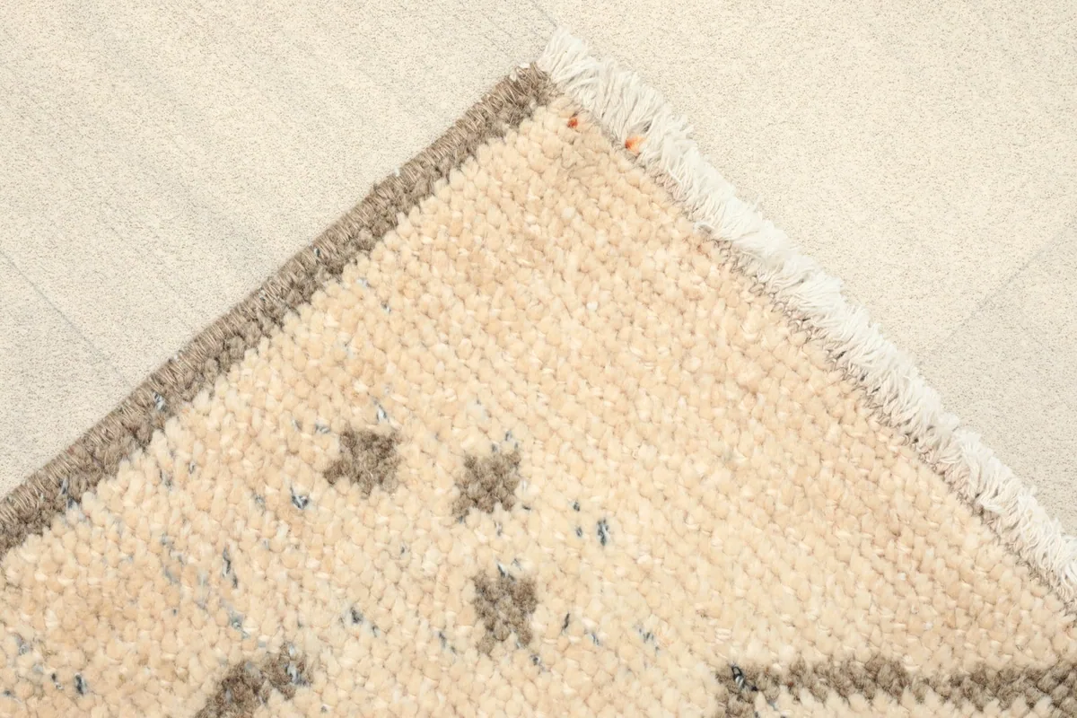 Corner detail showing the woven edge, fringe, and a hint of the cotton foundation.