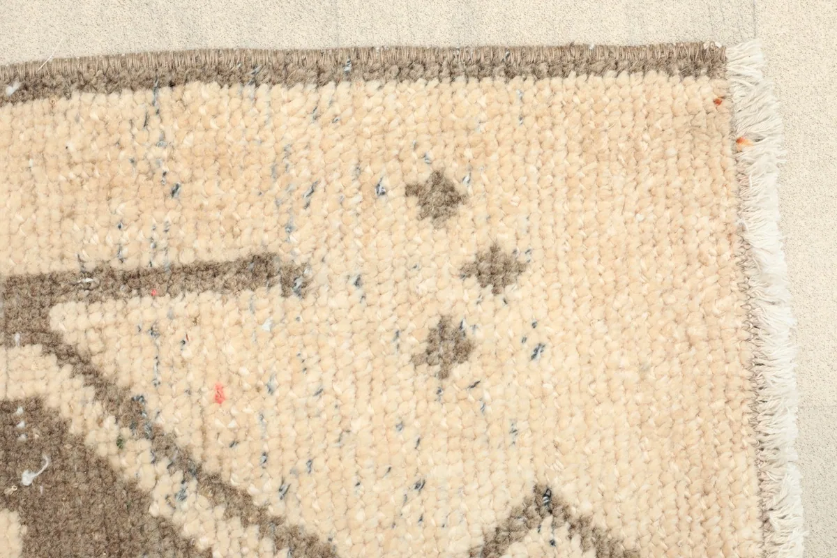 Close-up of the low wool pile, revealing the hand-knotted texture and fibers.