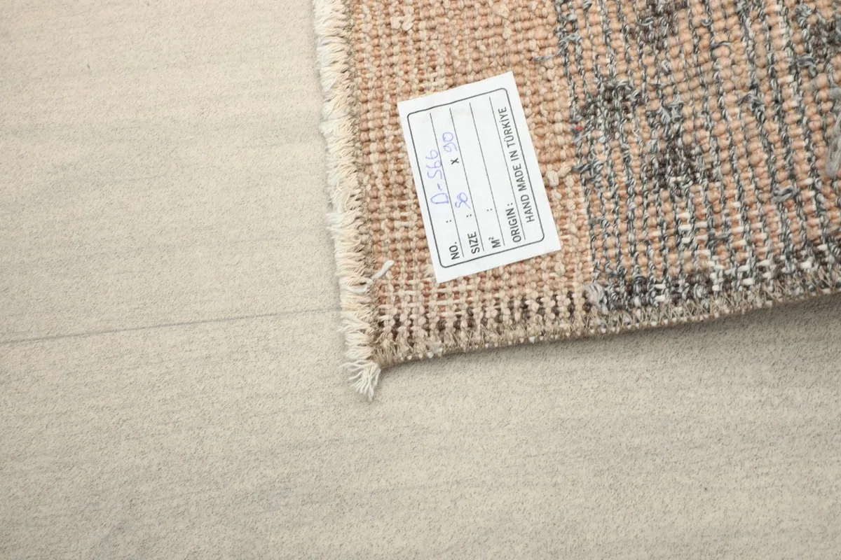 Close-up of the rug's back with a label indicating its origin and dimensions.