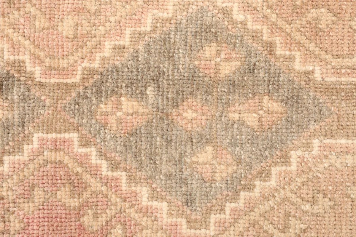 Close-up detail of the gray tribal geometric pattern with rose and beige accents
