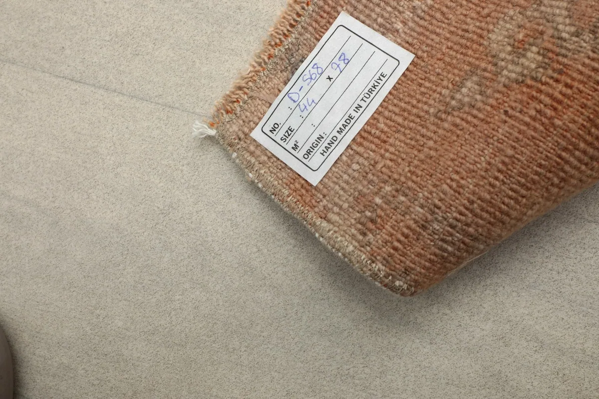 Back of the rug with a label, showing the cotton foundation and knotting